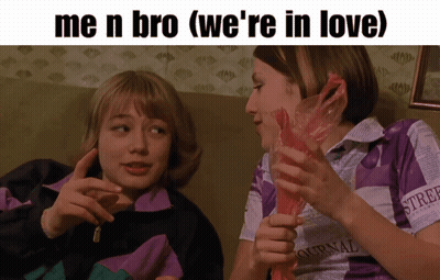 Two Girls On Couch One Wearing Ournal Shirt GIF