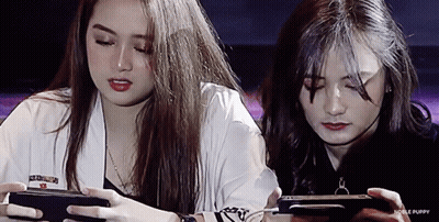 Two Girls Playing Game on Phones With Noble Puppy