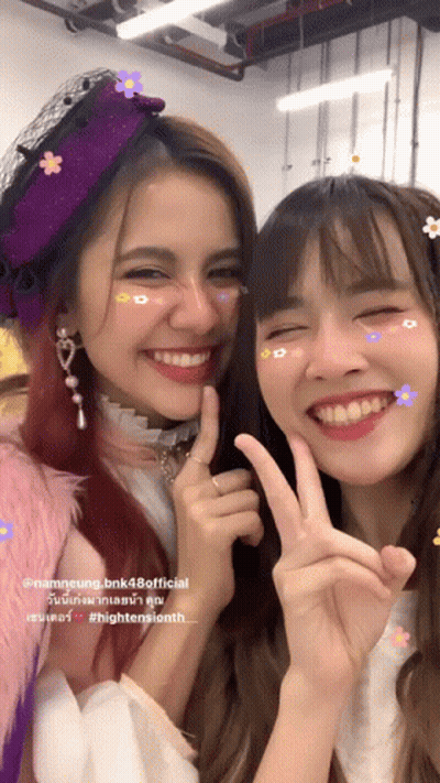 Two Girls Posing, One In Flower Hat GIF