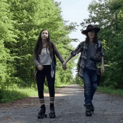 Two Girls Rollerblading On A Road Holding Hands GIF