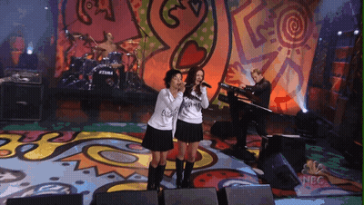 Two Girls Singing On Stage With NBC Logo GIF
