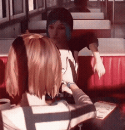 Two Girls Sitting In Diner Looking At Each Other GIF