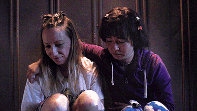 Two Girls Sitting Next To Each Other One In Purple Hoodie GIF