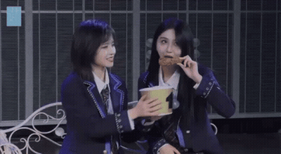 Two Girls Sitting On Bench Holding Bowl GIF