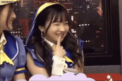 Two Girls Sitting, One Shushing GIF