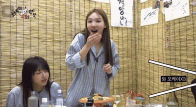 Two Girls Sitting Under Sign Saying X3 GIF