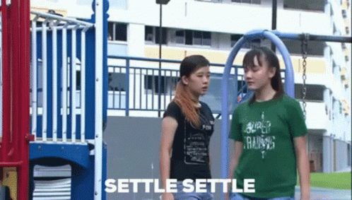 Two Girls Standing In Front Of A Playground With Settle Settle Written On The Bottom GIF