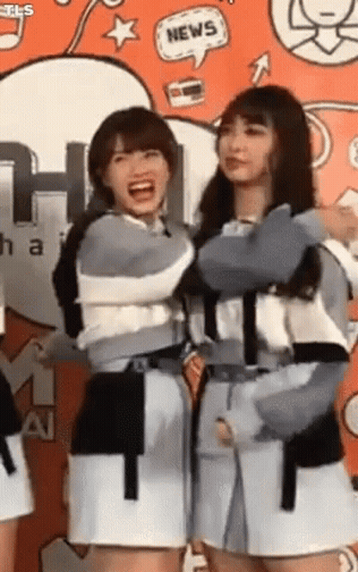 Two Girls Standing In Front Of Wall With News Speech Bubble GIF