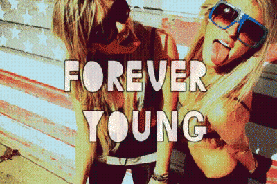 Two Girls Sticking Tongues Out In Front Of American Flag Forever Young GIF