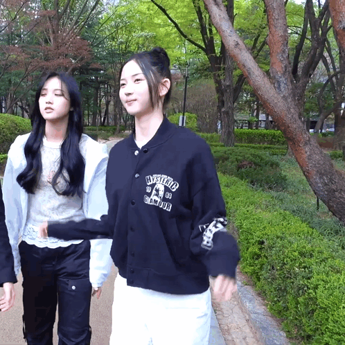 Two Girls Walking, One With Hysteria Sweatshirt GIF