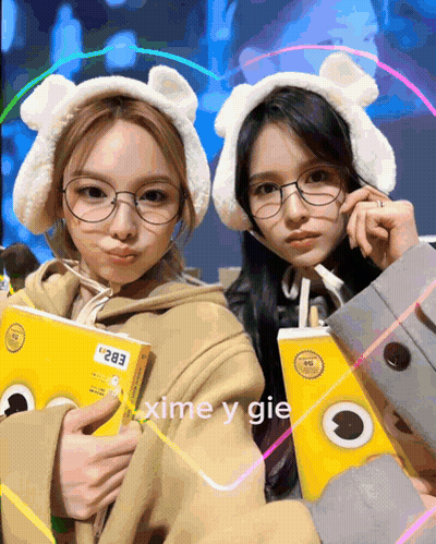 Two Girls With Glasses Ear Muffs Holding Boxes 283 GIF
