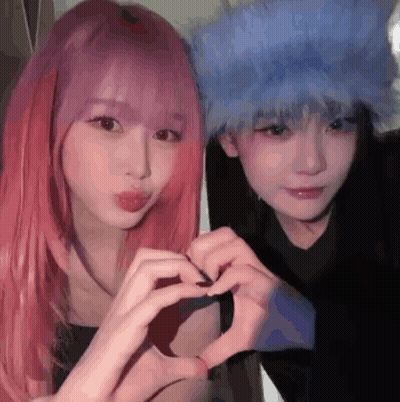 Two Girls With Pink Hair And Blue Hair Are Making A Heart Shape With Their Hands . GIF