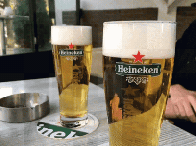 Two Glasses of Heineken Beer Next to Ashtray