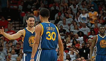 Two Golden State Warriors Basketball Players High Five Each Other During A Game GIF