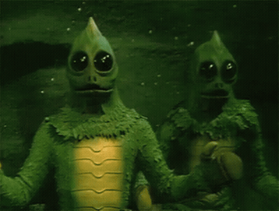 Two Green Aliens Standing Together GIF