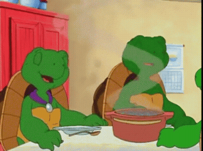 Two Green Turtles Sitting At Table With Soup GIF