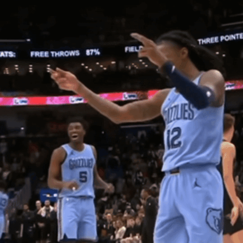 Two Grizzlies Basketball Players Are Standing On The Court GIF