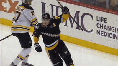 Two Hockey Players Are Celebrating A Goal In Front Of An Ad For Life Changing Medicine GIF