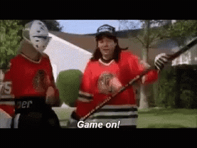 Two Hockey Players Holding Hockey Sticks And Puck GIF