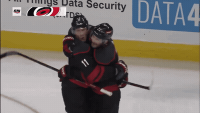 Two Hockey Players Hugging In Front Of Data Security Banner GIF