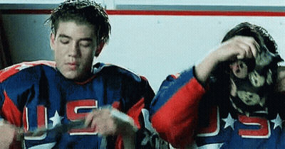 Two Hockey Players In Locker Room One Wearing Mask GIF