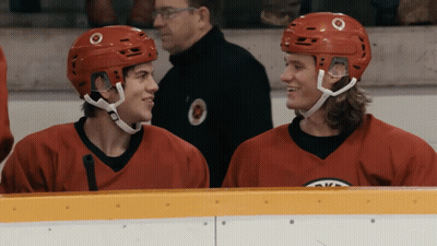 Two Hockey Players In Red Jerseys Sitting GIF