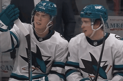 Two Hockey Players In Sap Helmets Sitting On Ice GIF