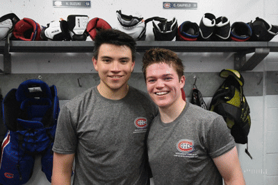 Two Hockey Players Posing In Locker Room With Gloves GIF