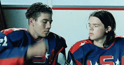 Two Hockey Players Sitting in Locker Room