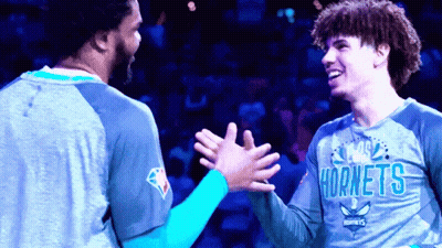 Two Hornets Players High Five Each Other On A Court GIF