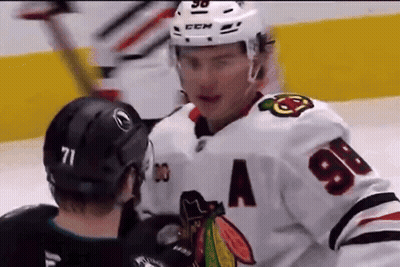 Two Ice Hockey Players Are Talking To Each Other On The Ice GIF