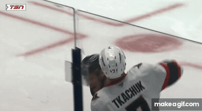 Two Ice Hockey Players Hugging During Game GIF
