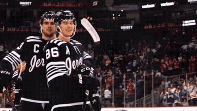 Two Ice Hockey Players In Black And White Jerseys With C86 A GIF
