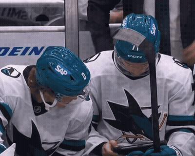 Two Ice Hockey Players Wearing Sap Helmets Looking At Something GIF
