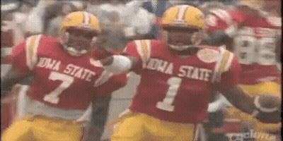Two Iowa State Football Players Are Running On The Field . GIF