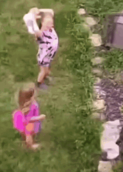Two Little Girls In Grass One Holding Hat GIF