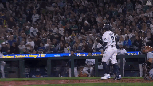 Two Mariners Baseball Players Are Standing Next To Each Other On The Field GIF