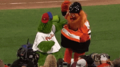 Two Mascots On Baseball Field, One In Phillies Shirt GIF