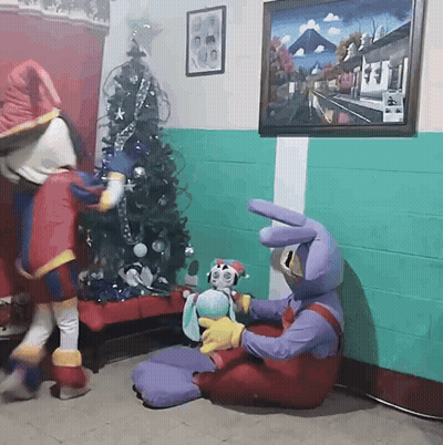 Two Mascots With Stuffed Animal Near Christmas Tree GIF