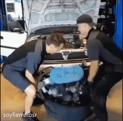 Dos mecánicos trabajando en motor de coche en garaje GIF