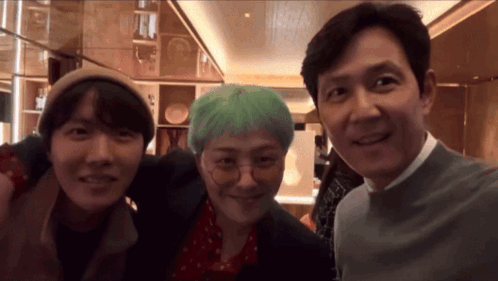 Two Men And A Woman Are Posing For A Photo Together GIF