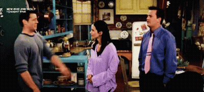 Two Men And A Woman Are Standing In A Kitchen With A Sign That Says New Mike And Molly GIF
