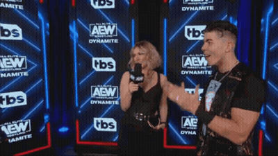 Two Men And A Woman Are Standing In Front Of A Wall That Says Aew GIF