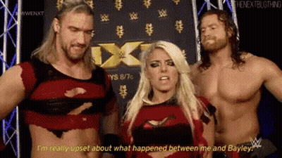 Two Men And Woman In Front Of NXT Sign GIF