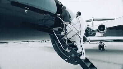 Two Men Are Boarding A Private Jet With The Word Jet On The Side Of It GIF