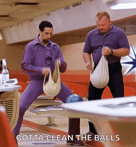 Two Men Are Cleaning Bowling Balls In A Bowling Alley With The Words Gotta Clean The Balls Below Them . GIF