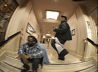 Two Men Are Dancing In A Hallway With A Sign On The Wall That Says ' Exit ' GIF