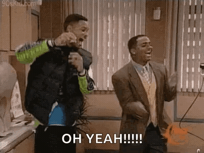 Two Men Are Dancing In A Kitchen And One Of Them Is Holding A Microphone . GIF