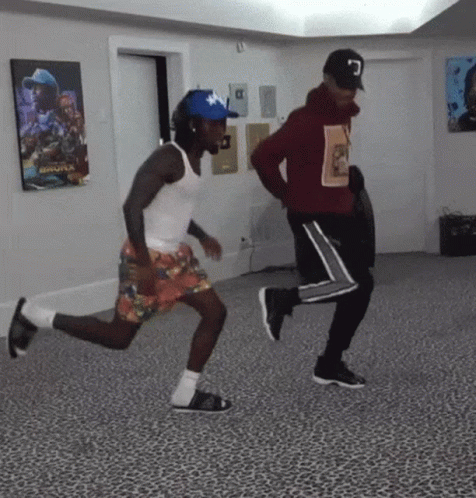 Two Men Are Dancing In A Room With A Leopard Print Floor . GIF