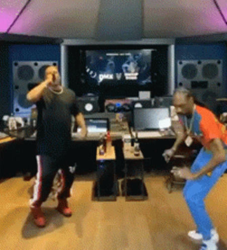Two Men Are Dancing In Front Of A Screen That Says Pax V. GIF